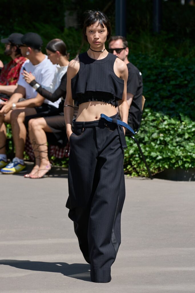 A relaxed black cropped sleeveless top paired with high-waisted wide-leg pants.