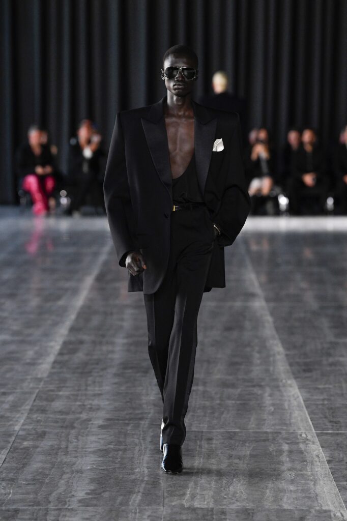 A tailored black wool blazer with a V-neckline and structured silhouette paired with matching pants.