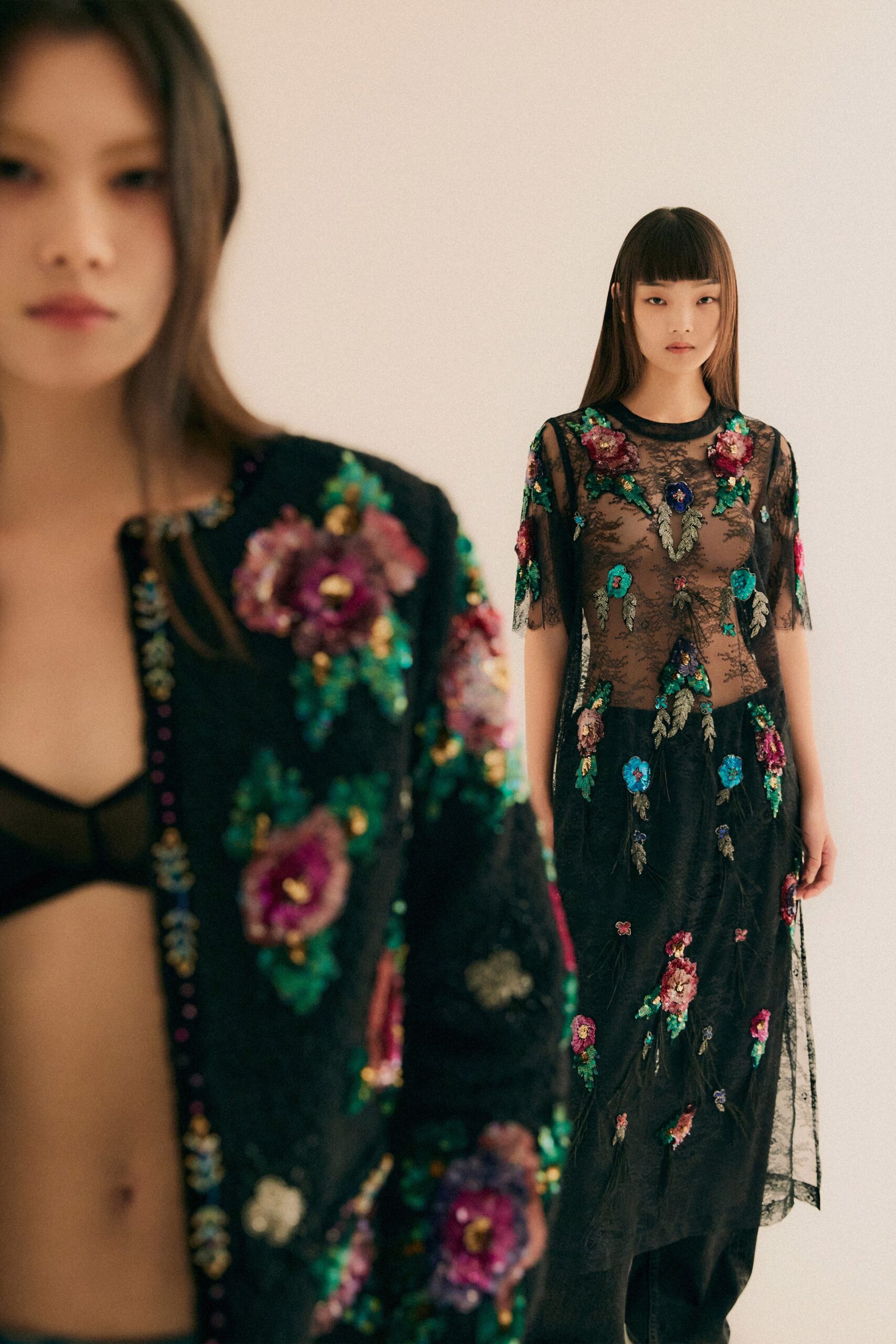 A fitted black lace dress with short sleeves and intricate embroidery details.