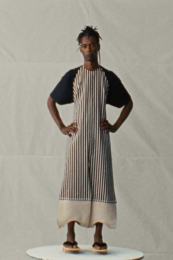 A relaxed black and beige striped dress with short sleeves and a tiered design.