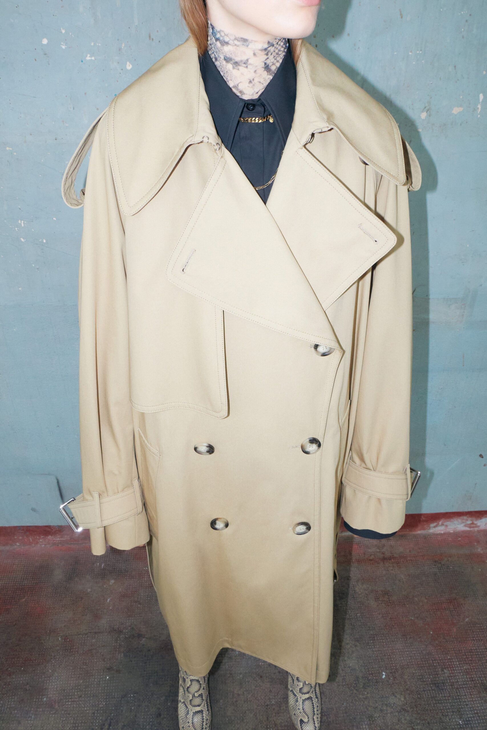 An oversized beige coat with long sleeves and a double-breasted design.