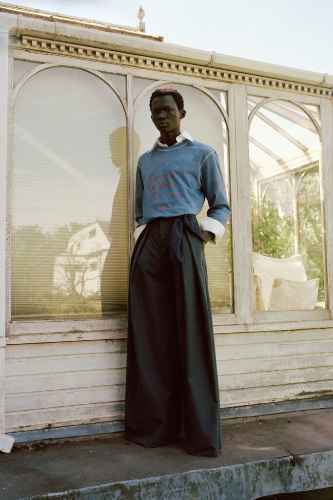 A relaxed blue cotton long-sleeve top paired with wide-leg black pants.
