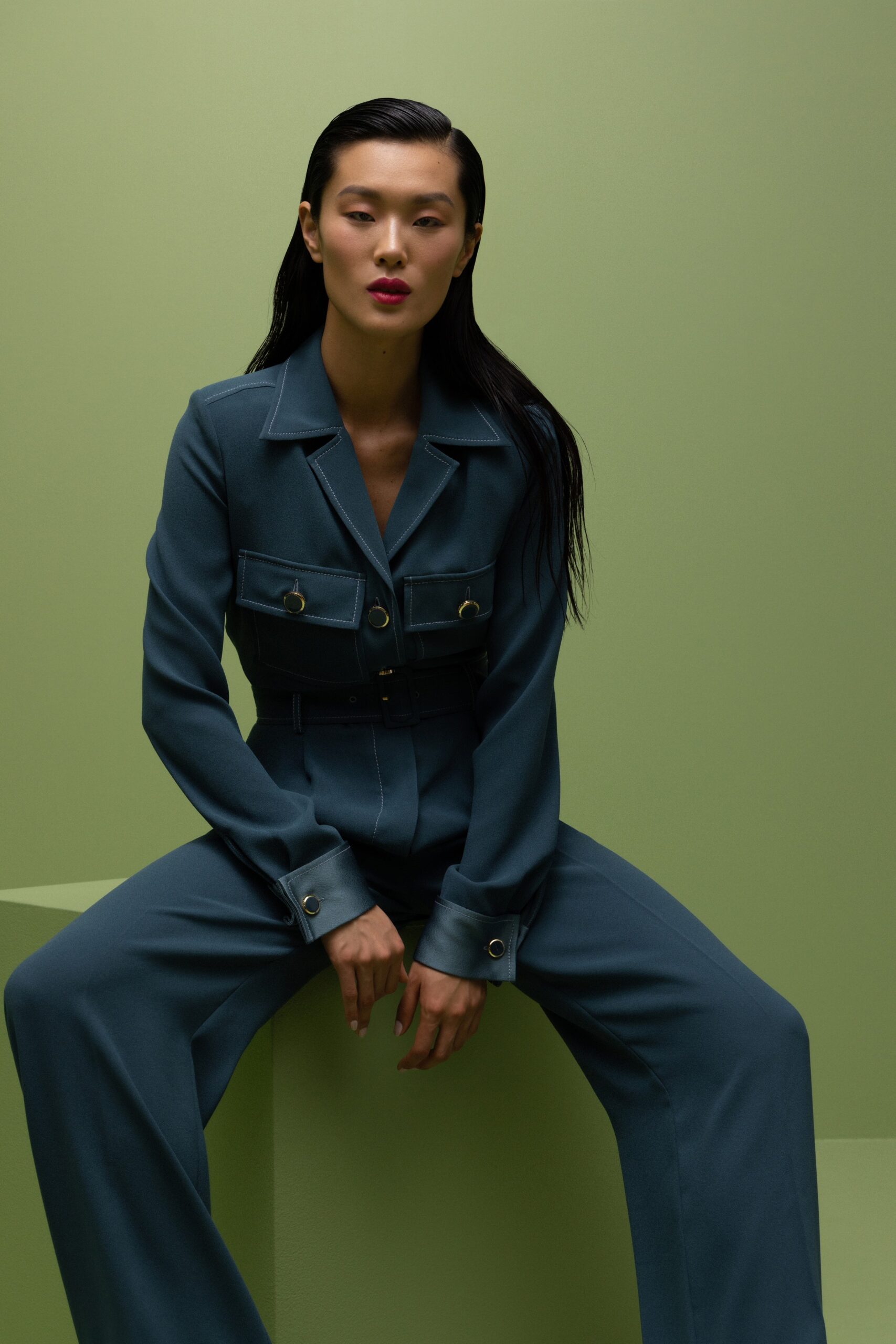 A fitted blue cotton suit with long sleeves, a collared neckline, and wide-leg trousers.