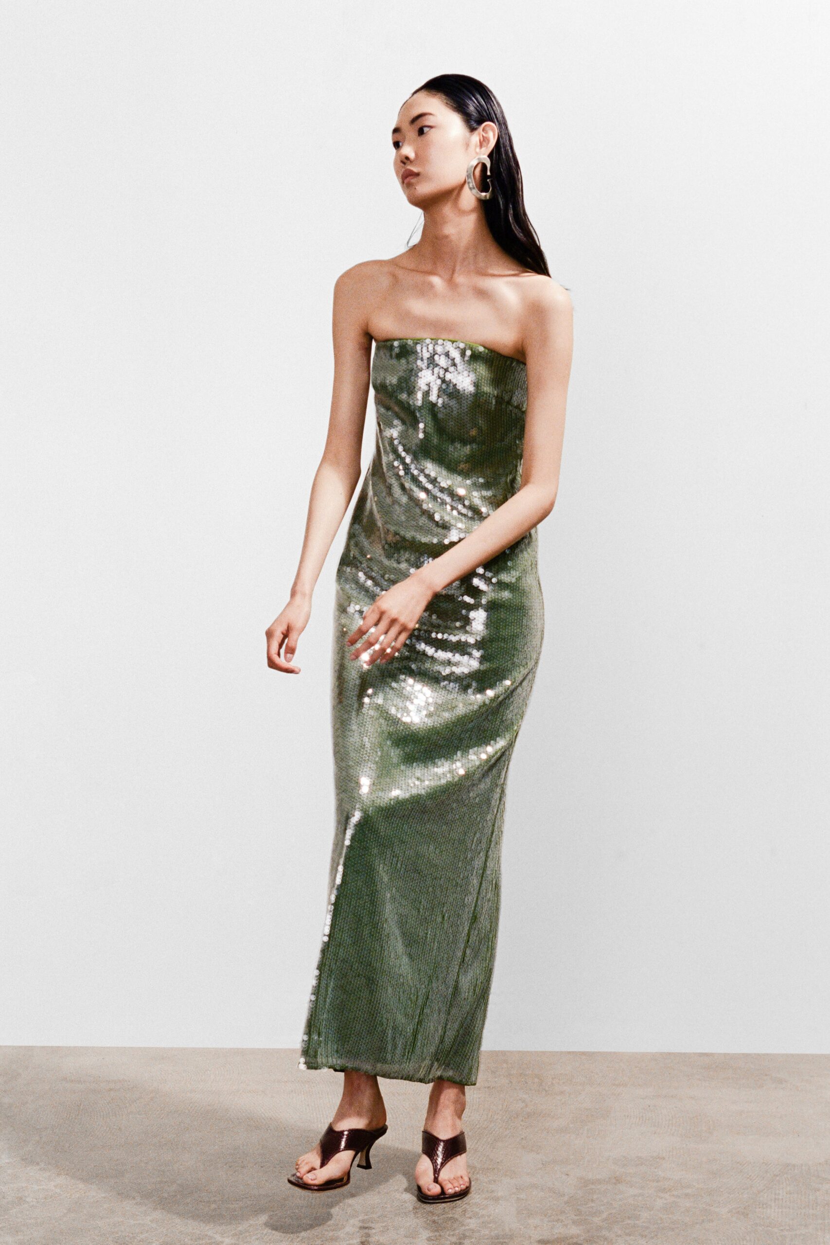 A fitted green sequin dress with a sleeveless design and a straight maxi silhouette.