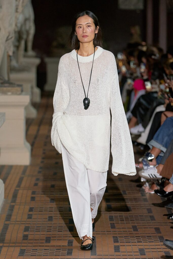 A relaxed white cotton long-sleeve top with an asymmetric design paired with matching pants.