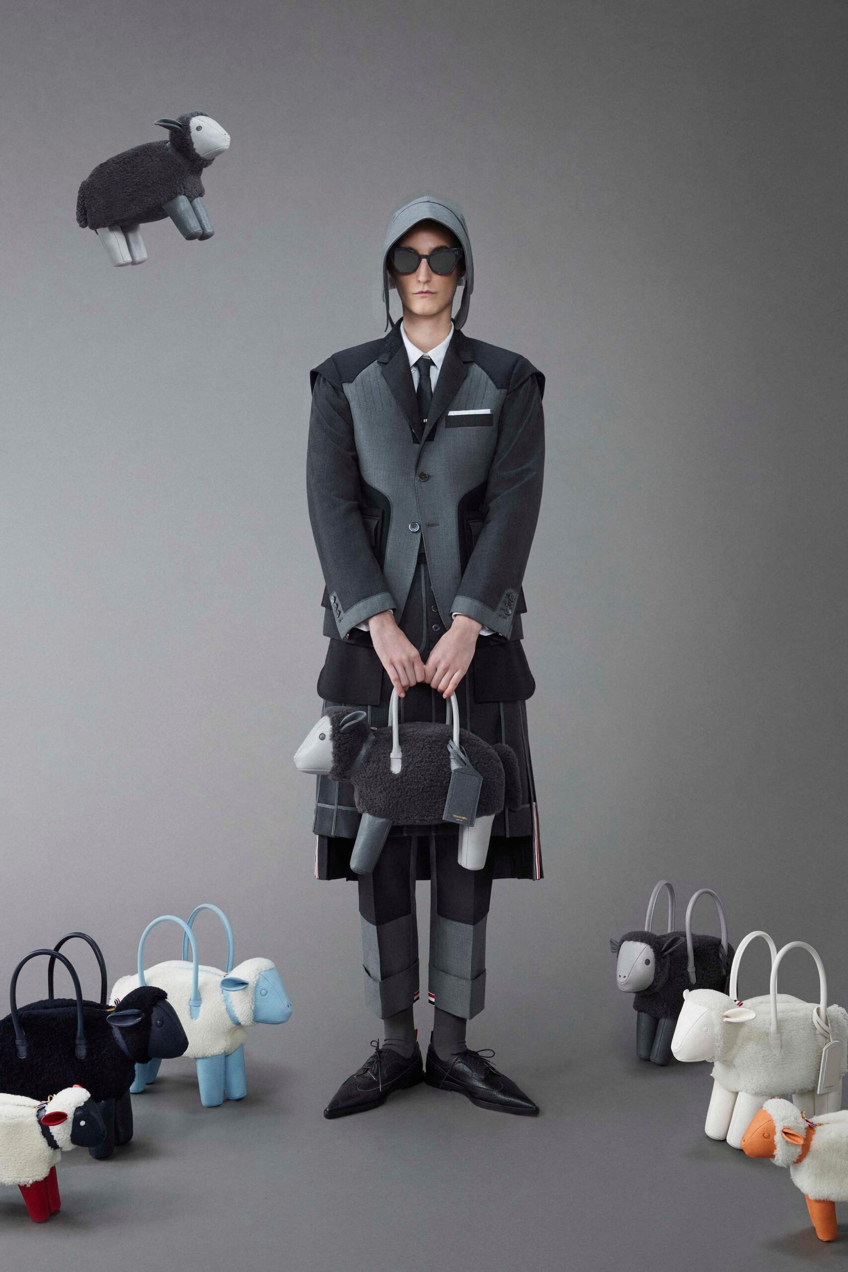 A structured gray suit featuring a collared jacket with an asymmetric layered design.