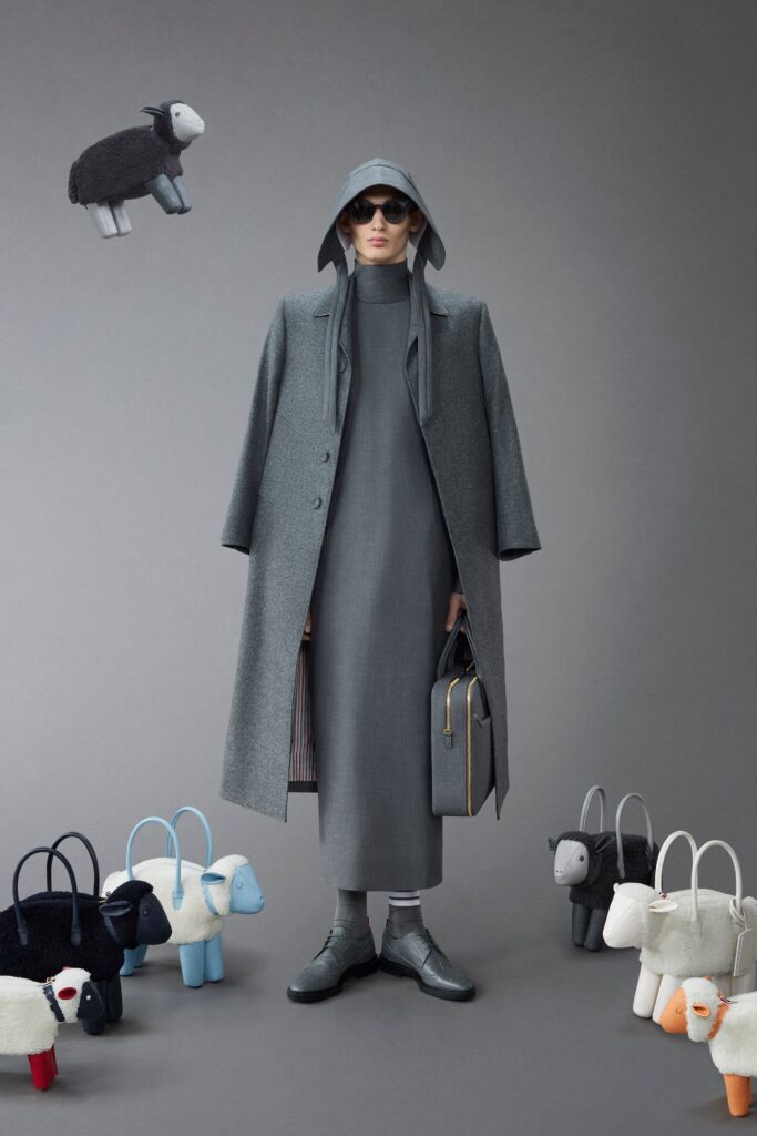 A fitted gray wool coat layered over a straight-leg dress with a high neckline.