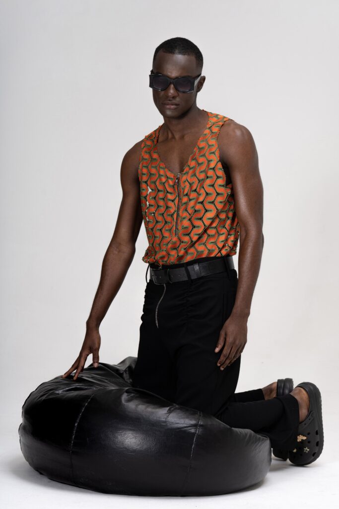A fitted orange printed sleeveless top paired with black fitted pants.