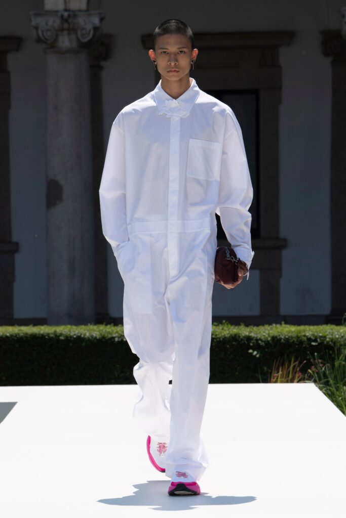 A relaxed white cotton jumpsuit with long sleeves and a collared neckline, featuring buttoned details.