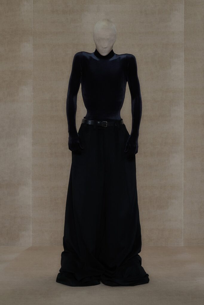 A relaxed black velvet long-sleeve top with high-neck and wide-leg pants.