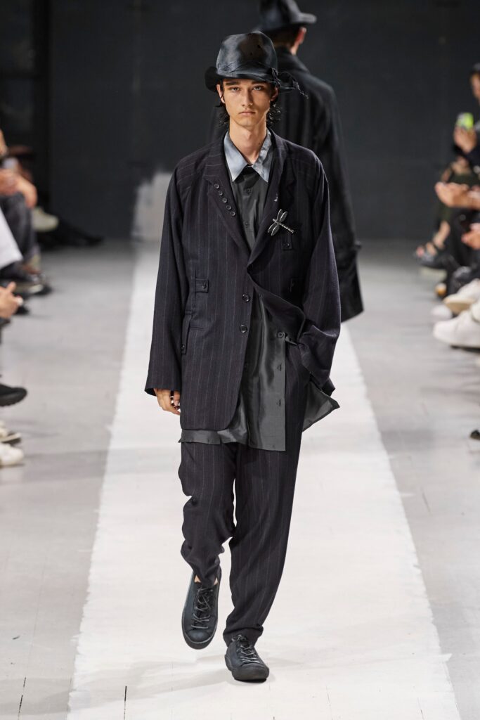 A relaxed black striped suit with long sleeves and a collared shirt.