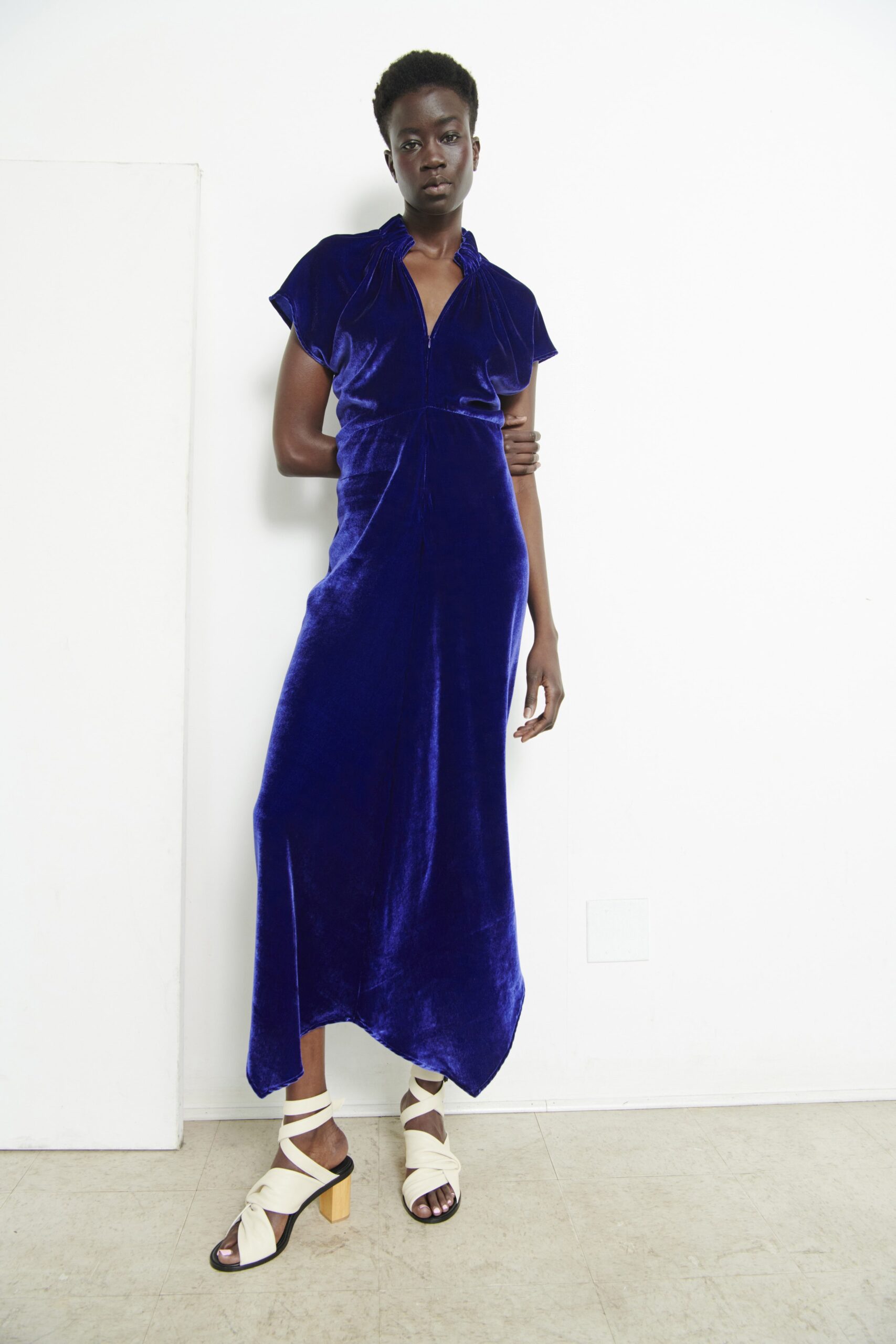 A fitted blue velvet dress with short sleeves and a V-neckline in a maxi silhouette.