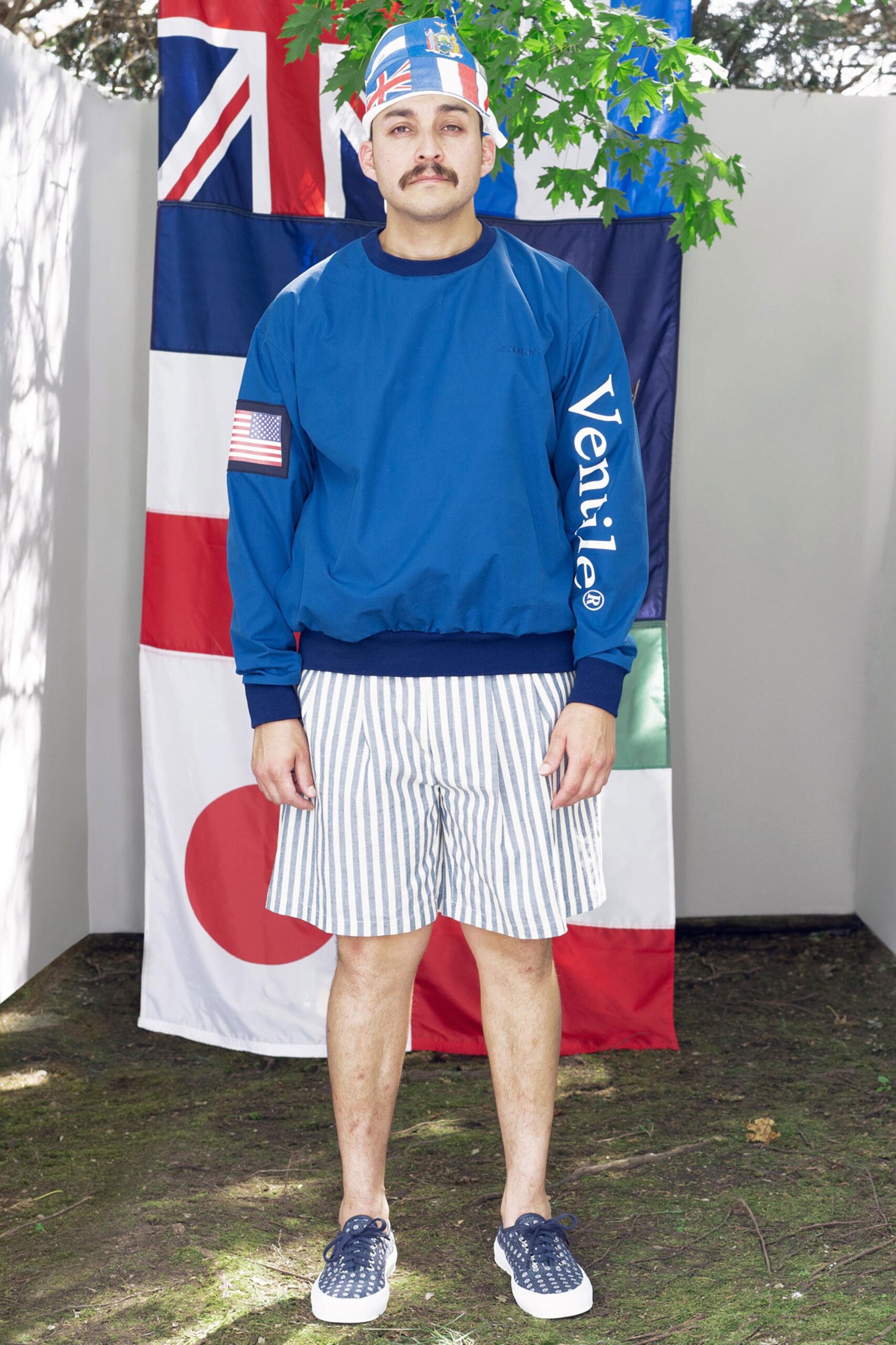 A relaxed blue long-sleeve sweater paired with white striped shorts for a casual look.