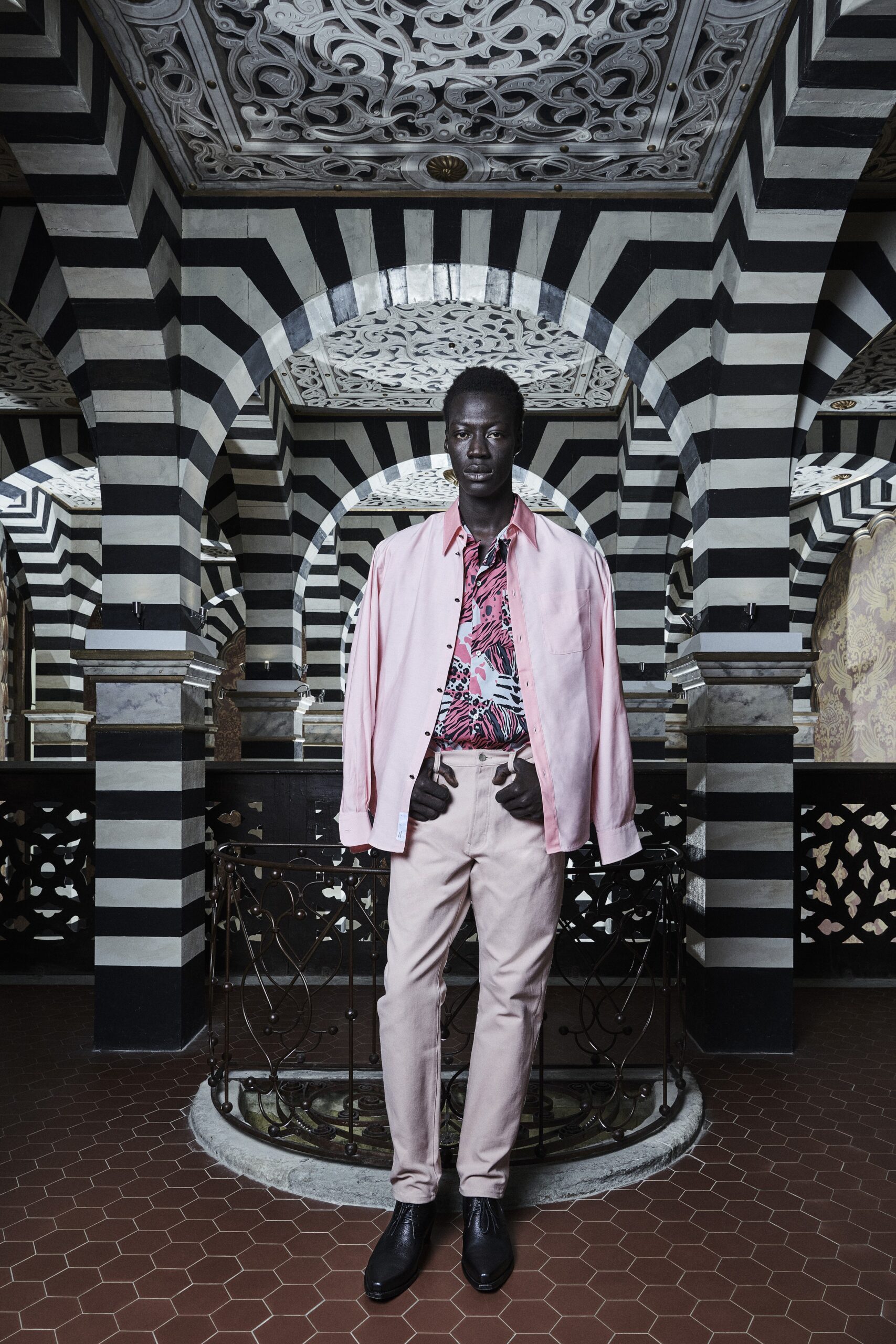 A relaxed pink printed shirt paired with beige pants, featuring a collared neckline.