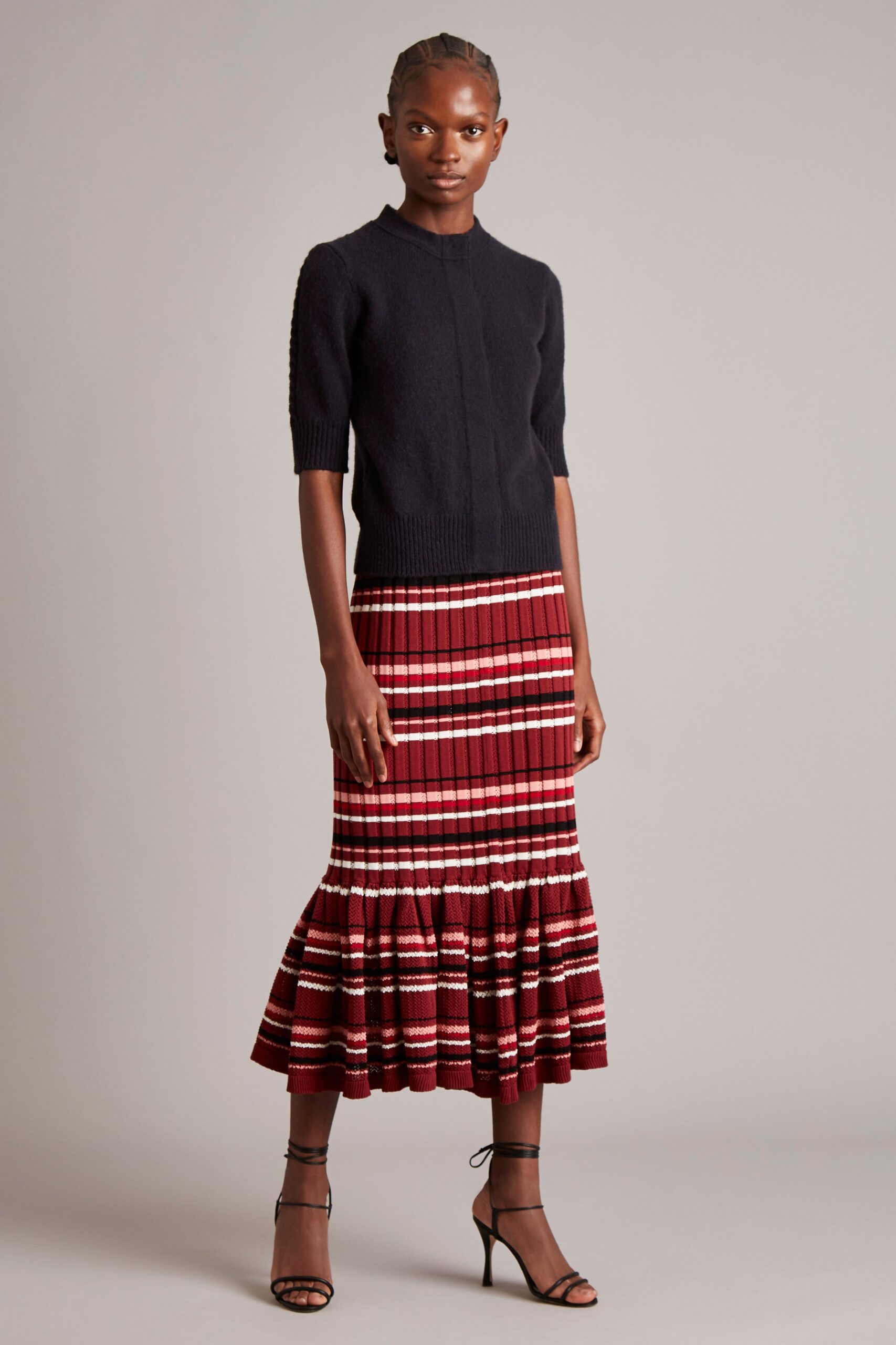 black fitted top and red flared skirt