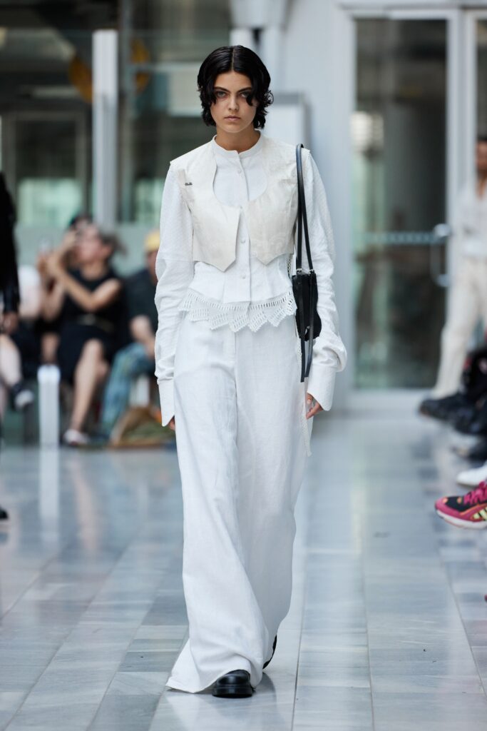 A fitted white vest paired with long white pants, creating a sleek and modern silhouette.