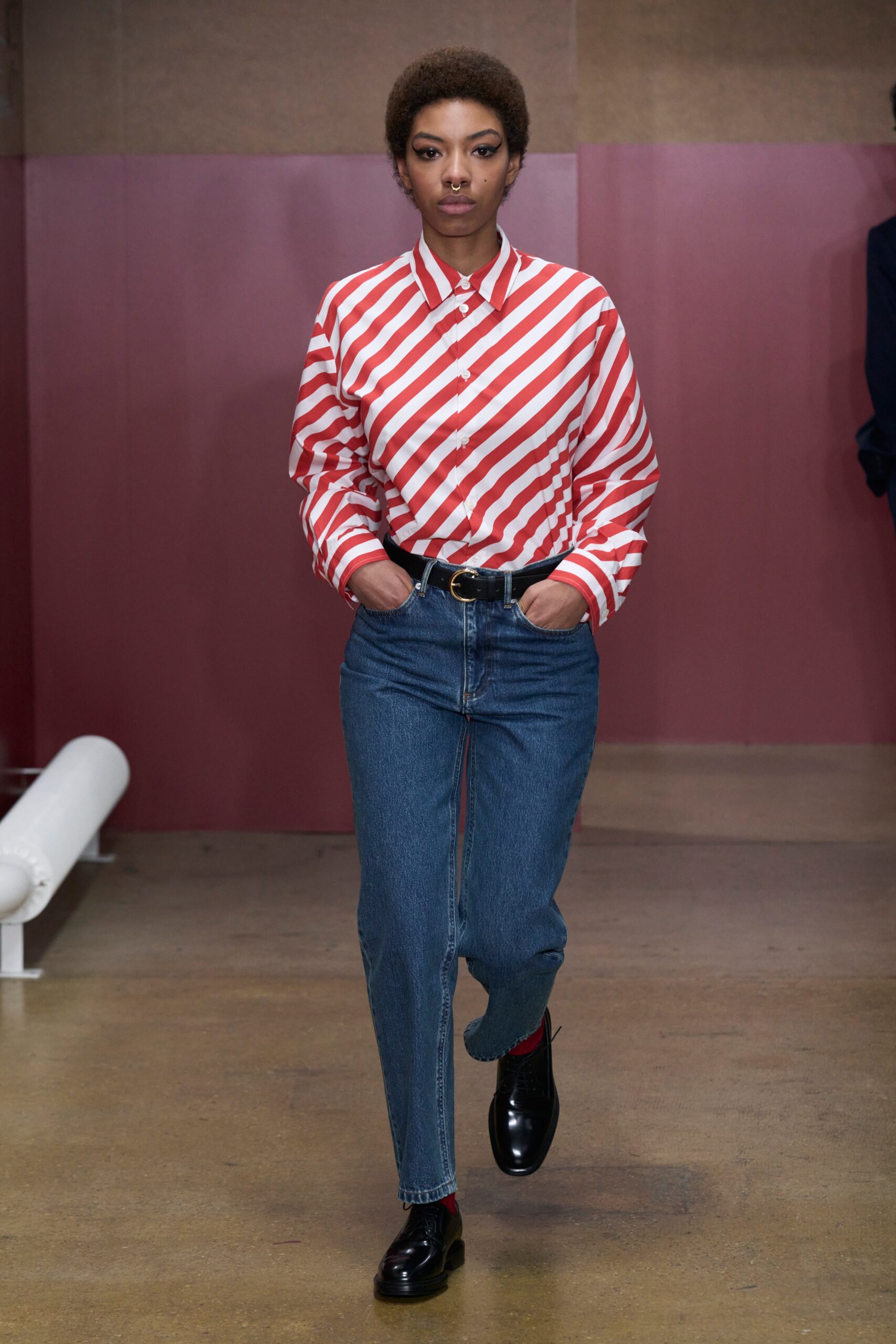 A relaxed long-sleeve collared shirt with red and white stripes paired with straight-leg blue jeans.