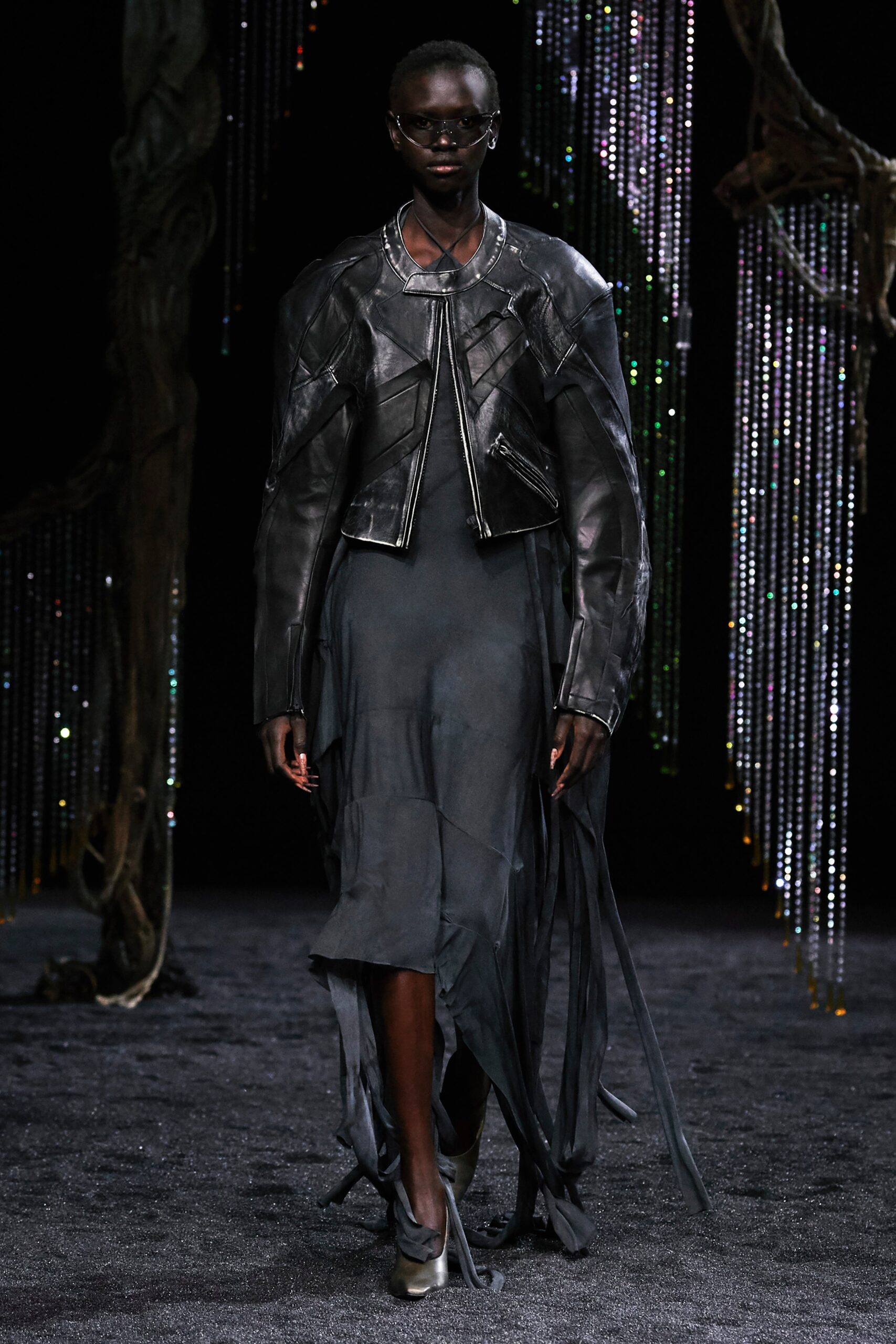 A fitted black leather dress with an asymmetric design, paired with a matching jacket.