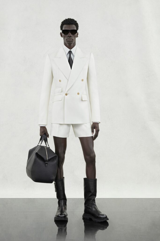 A tailored white blazer with long sleeves and collared neckline, paired with matching shorts.