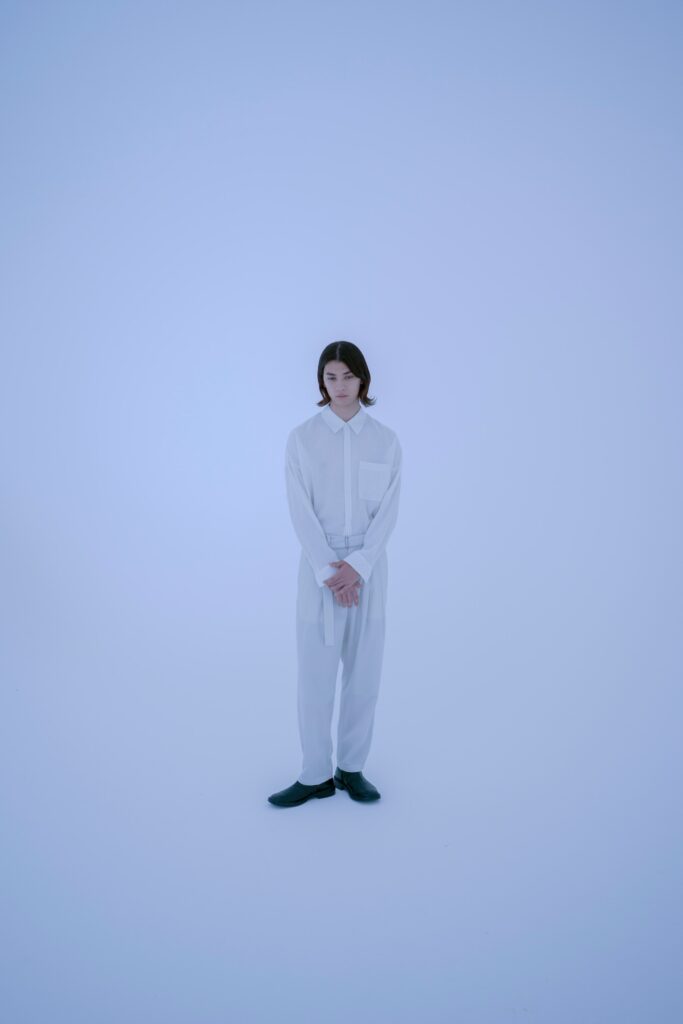 A relaxed white long-sleeve collared shirt paired with straight-leg pants.