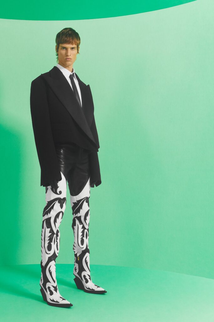A tailored black jacket paired with fitted white pants featuring a striking design.