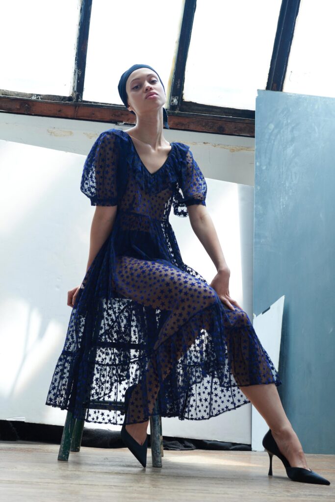 A fitted blue lace short-sleeve dress with a V-neckline and tiered design.