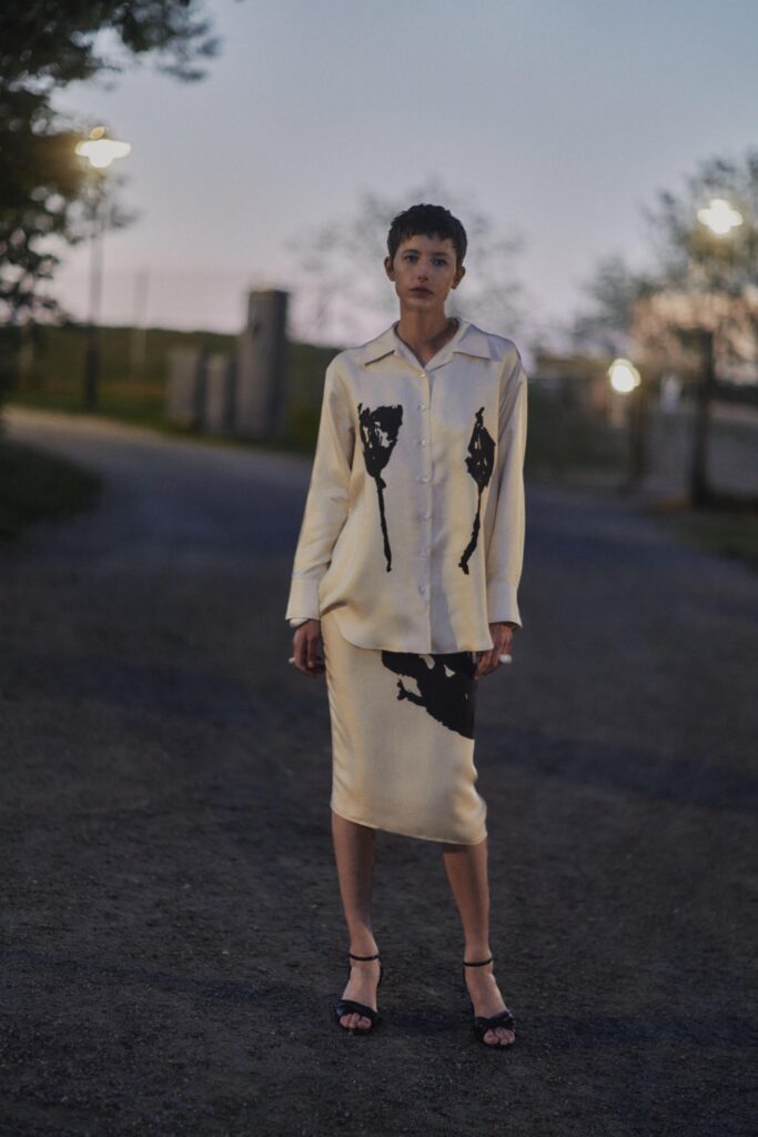 A relaxed cream silk dress with long sleeves, a collared neckline, and a printed design.