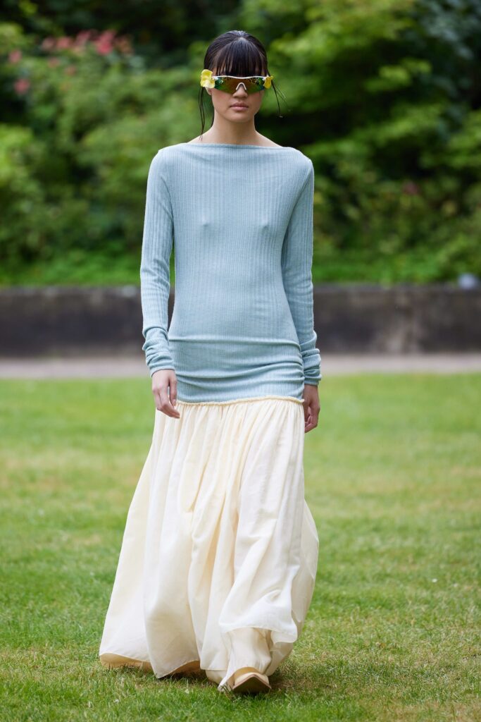 A fitted blue long-sleeve top paired with a cream tiered skirt, creating a stylish contrast.
