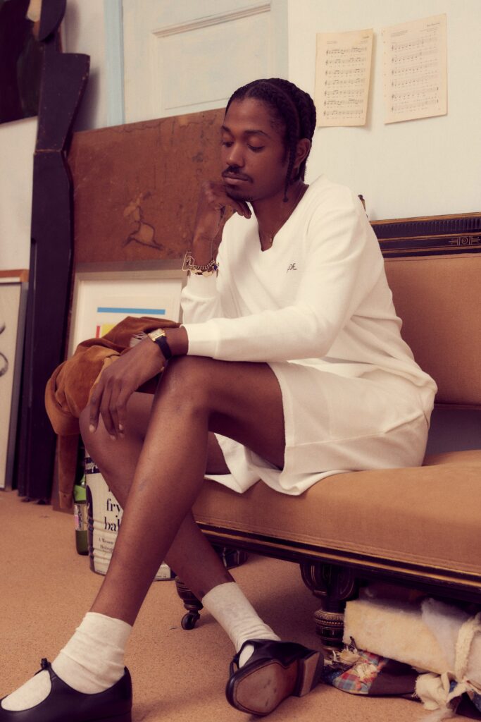 A relaxed white cotton dress with long sleeves and a collared neckline.