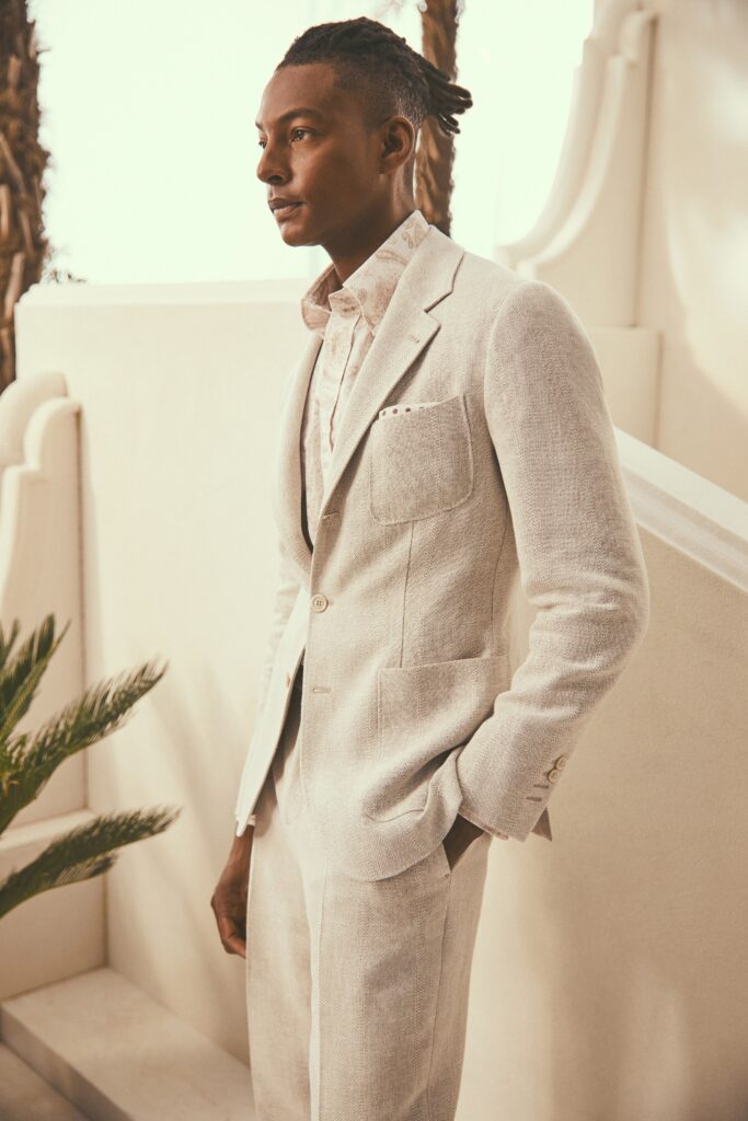 A tailored beige linen suit with a long-sleeve collared shirt and buttoned details.