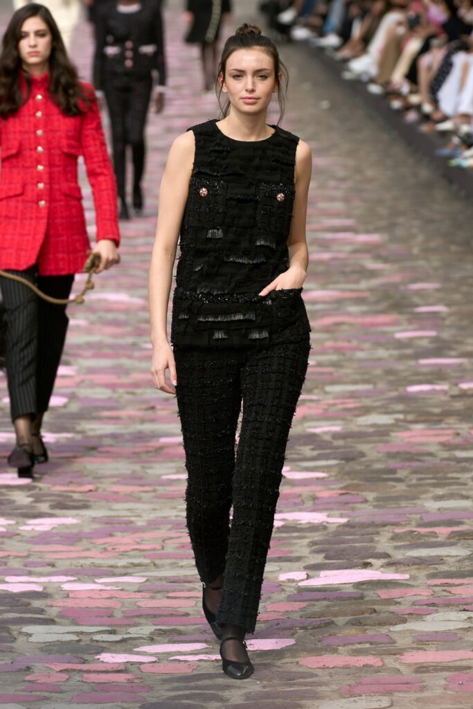 A fitted black sleeveless top paired with matching fitted pants, featuring a layered design.