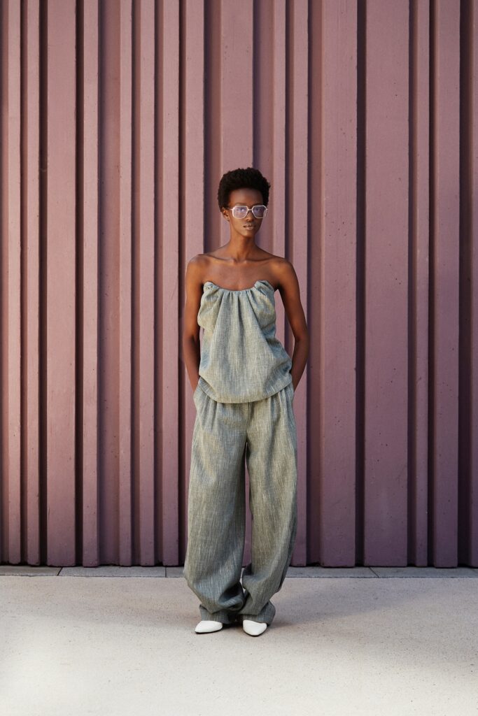 A relaxed gray sleeveless top paired with matching pleated pants for a stylish look.