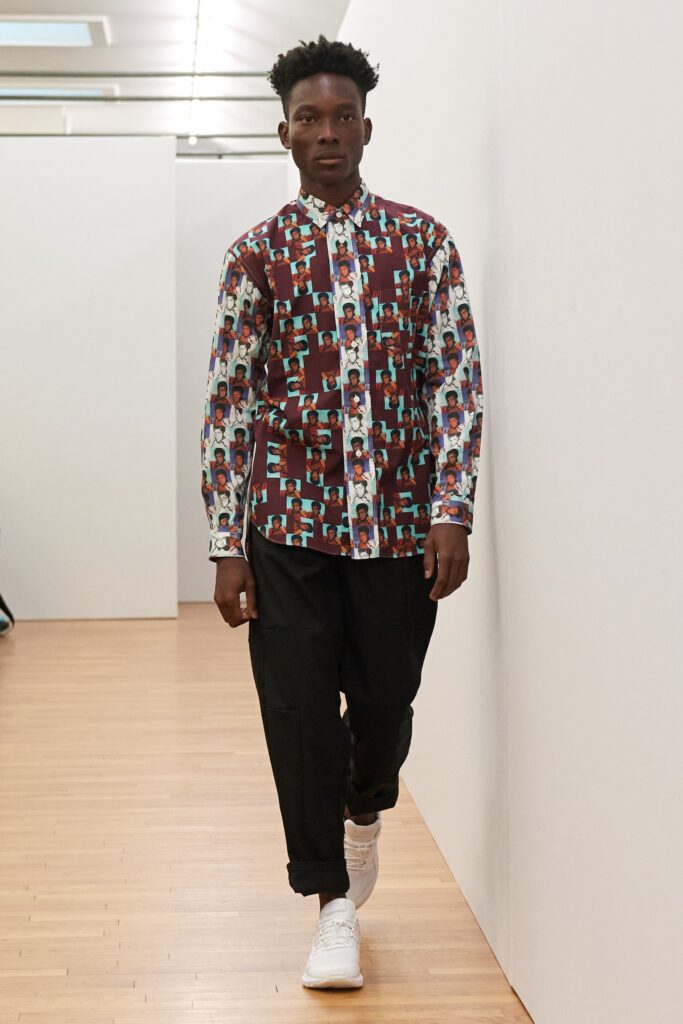 A relaxed-fit multicolor printed shirt paired with black pants, featuring a long-sleeve and collared design.