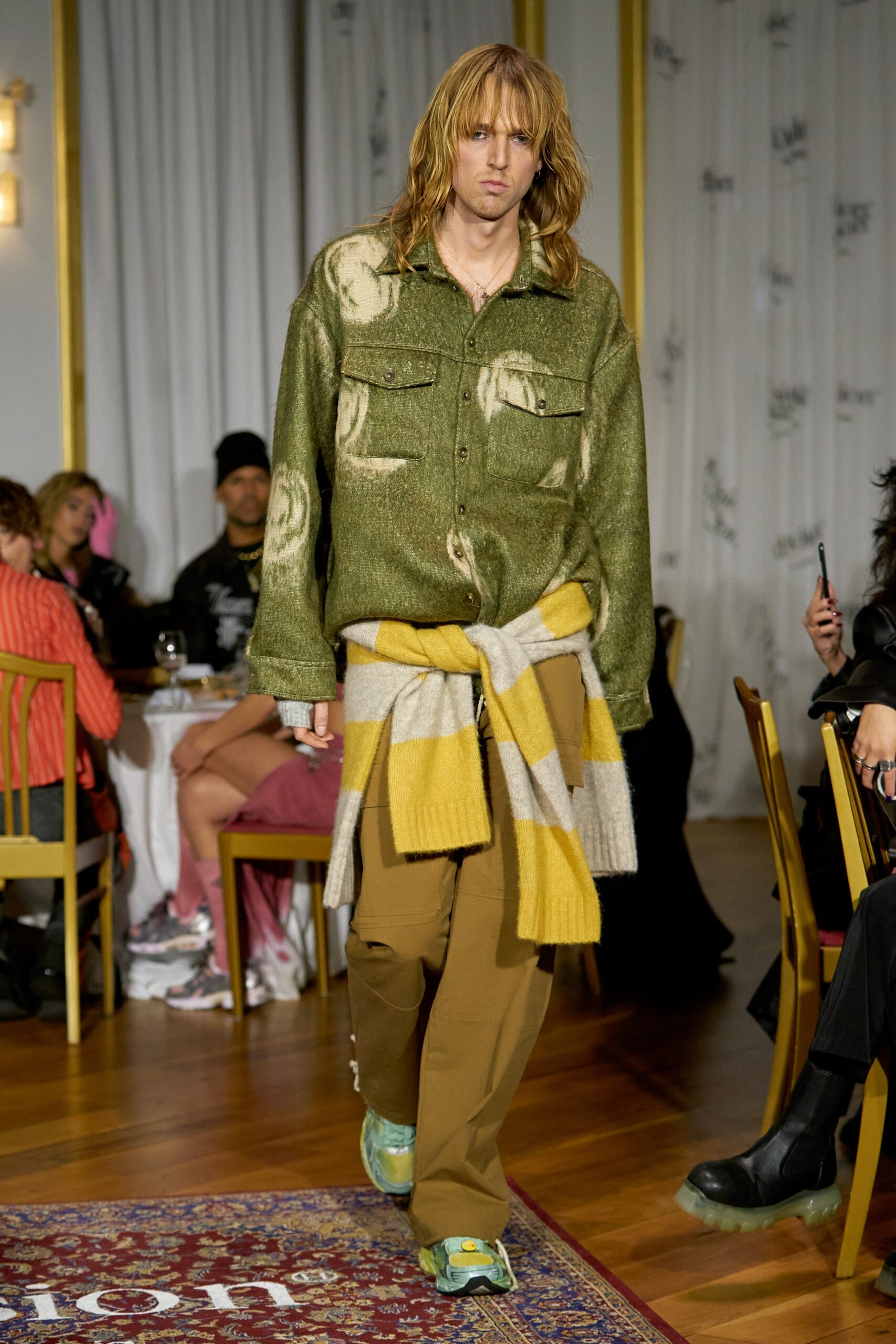 A relaxed green cotton long-sleeve shirt paired with brown pants, featuring a layered look.