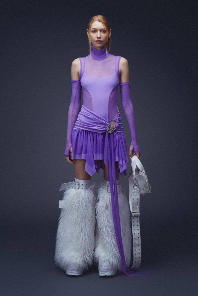 A fitted purple mesh dress with a high neckline and asymmetric design details.