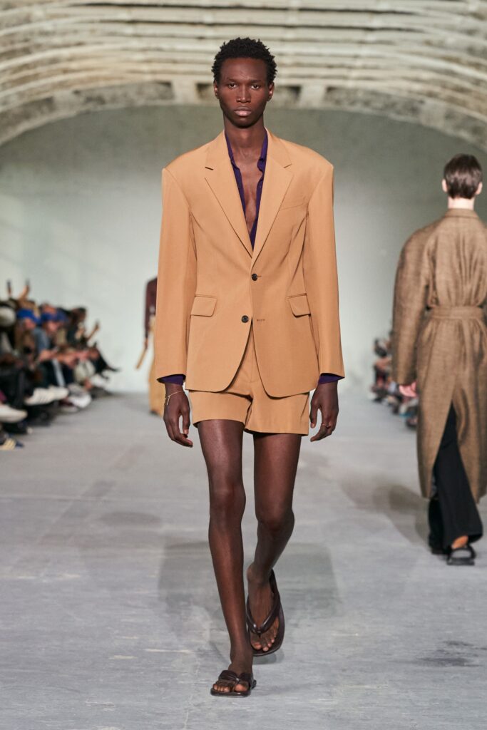 A tailored beige suit with a collared long-sleeve shirt and matching shorts.