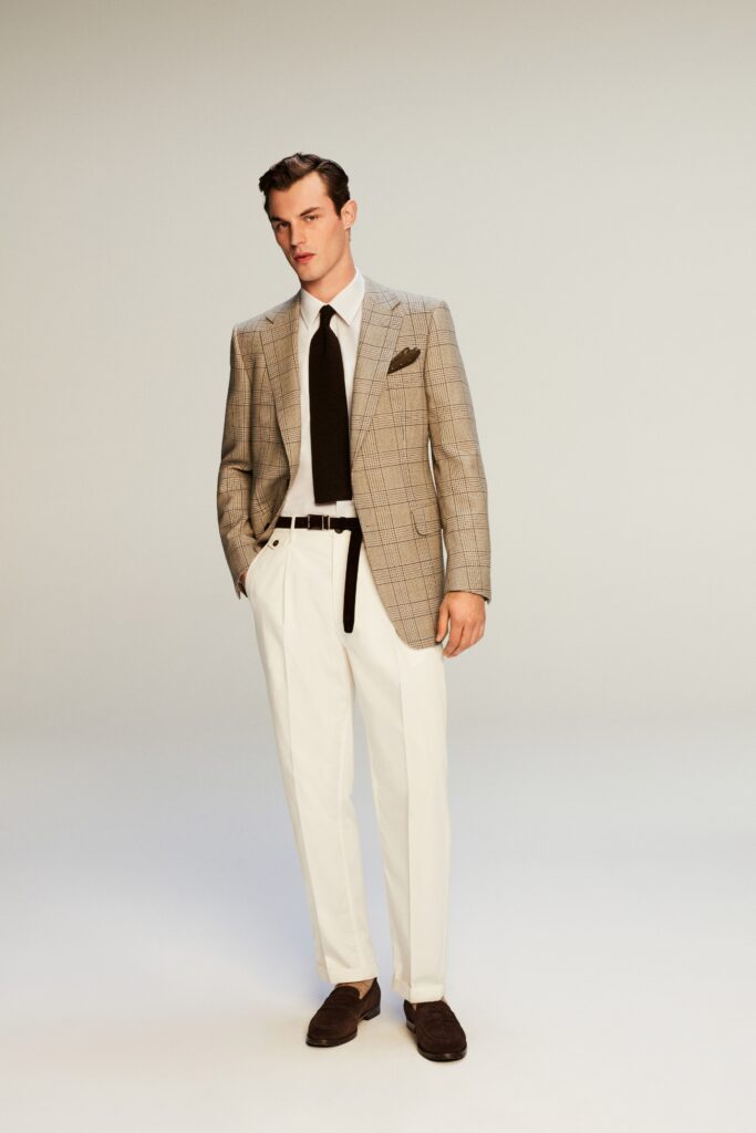 A tailored beige checked blazer paired with white trousers, featuring a collared shirt.