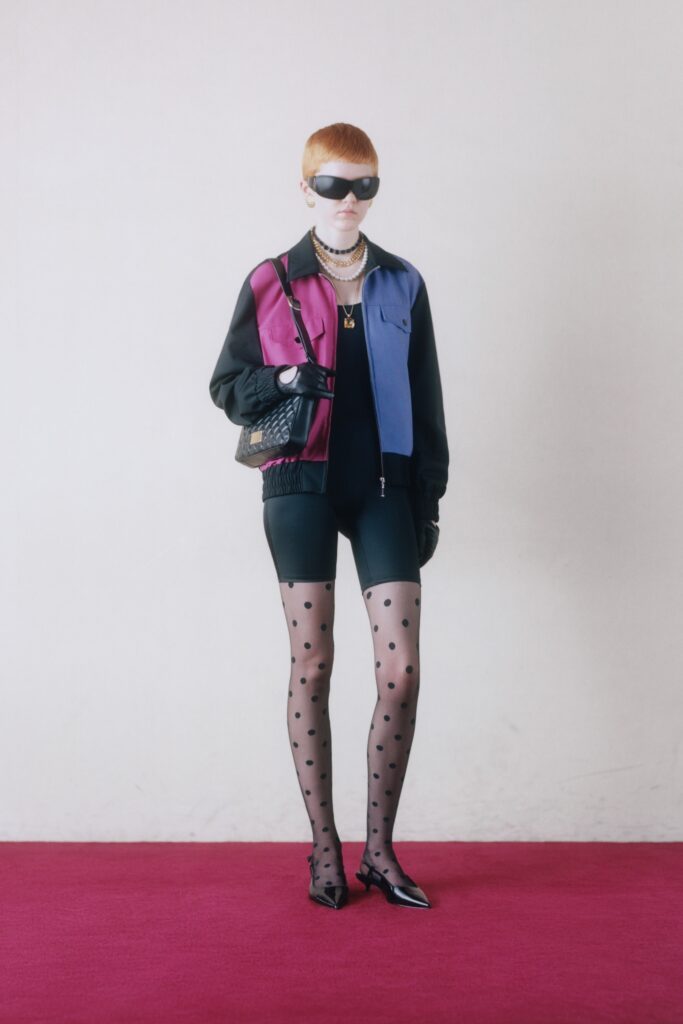 A fitted color-blocked jacket paired with black polka-dot shorts, creating a stylish ensemble.