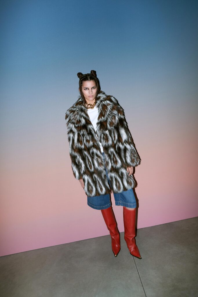 A relaxed brown fur coat paired with blue denim shorts, featuring a collared design and printed texture.