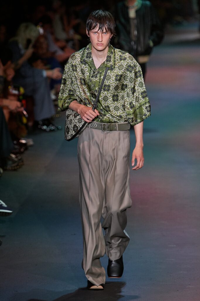 A relaxed fit green printed shirt with short sleeves paired with wide-leg gray pants.