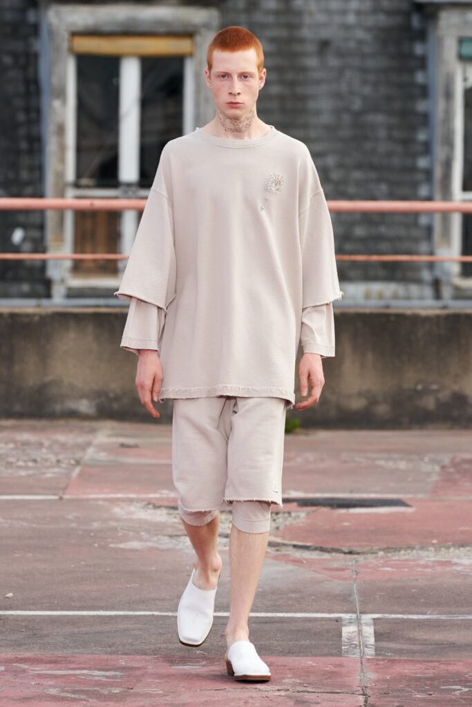 A relaxed beige cotton top with short sleeves and fringed detailing paired with matching shorts.