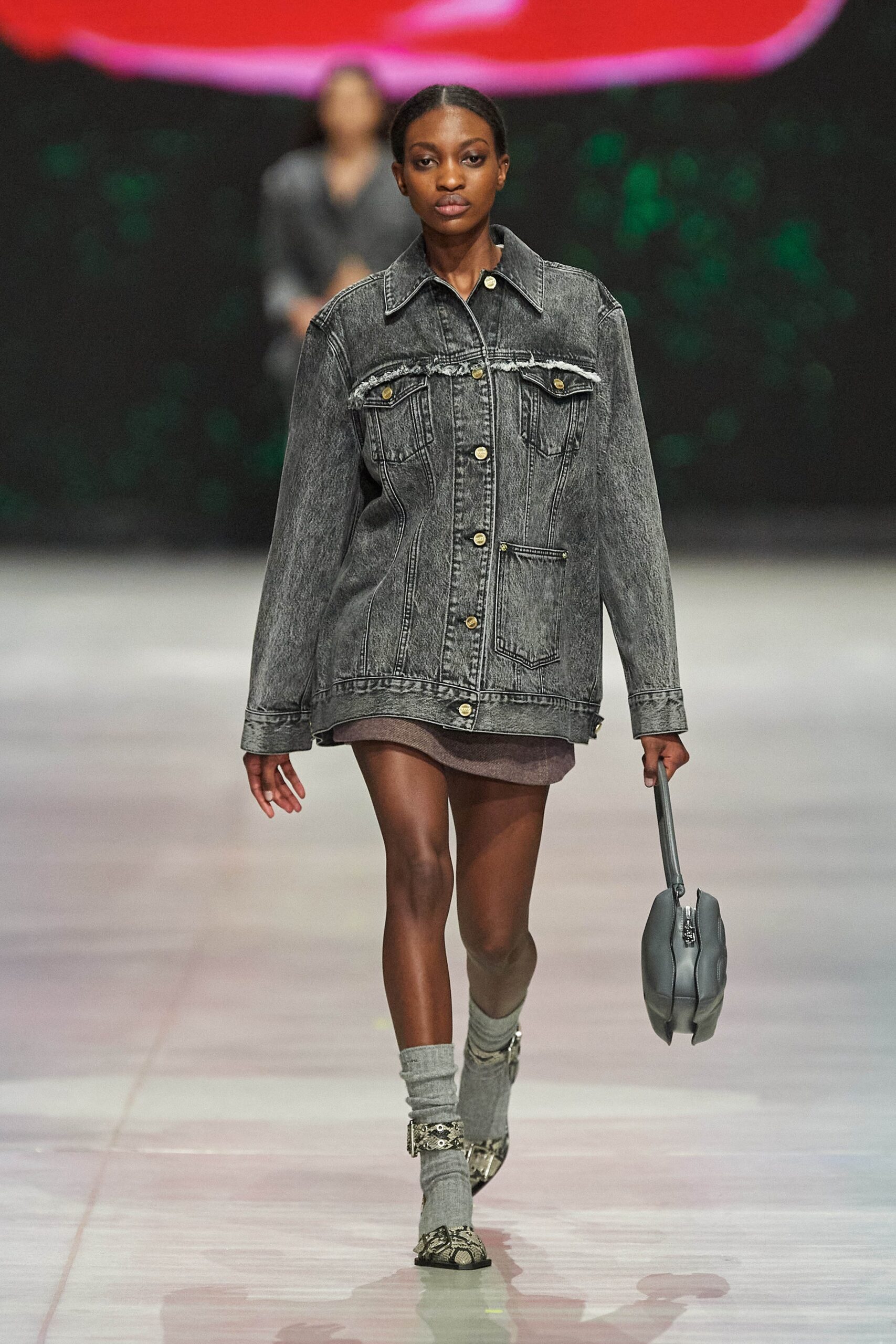 An oversized gray denim jacket layered over a dress, featuring a collared design.