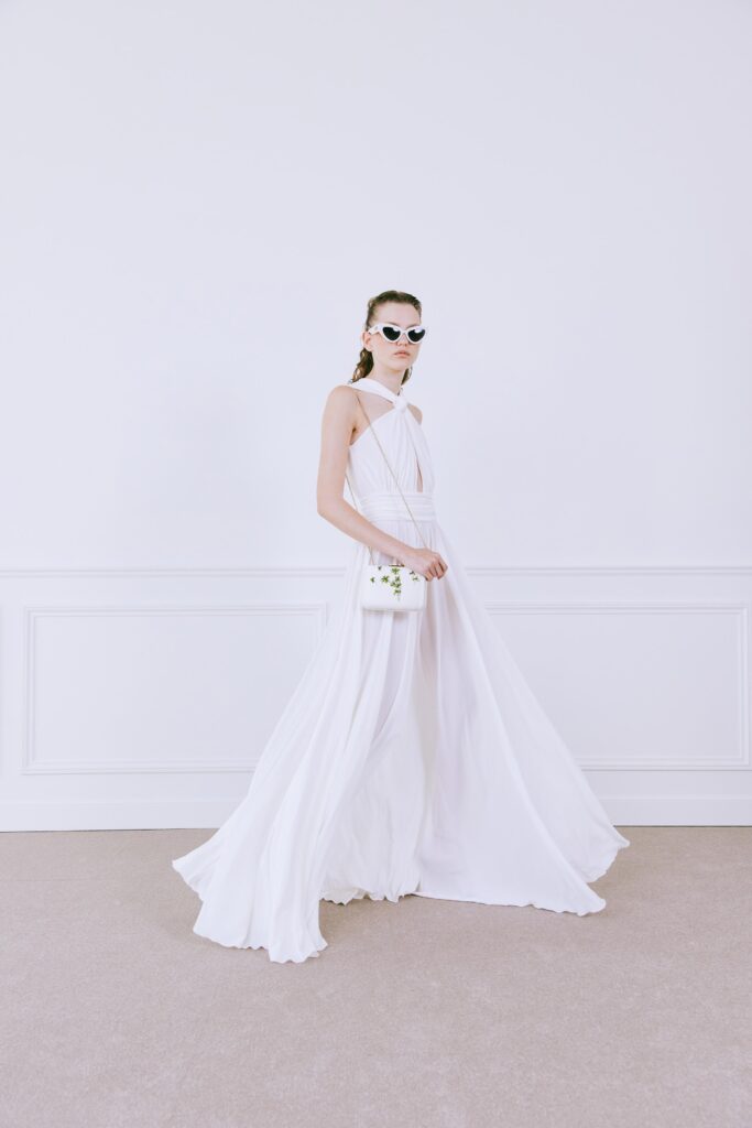A fitted white silk sleeveless dress with a V-neckline and a flowy silhouette.