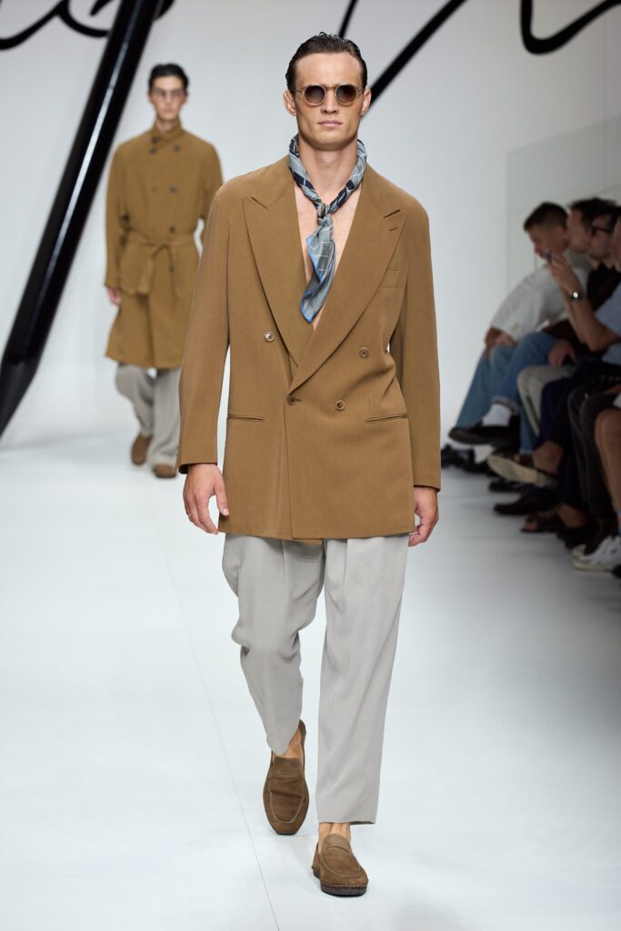 A relaxed brown double-breasted jacket paired with beige pants for a stylish look.