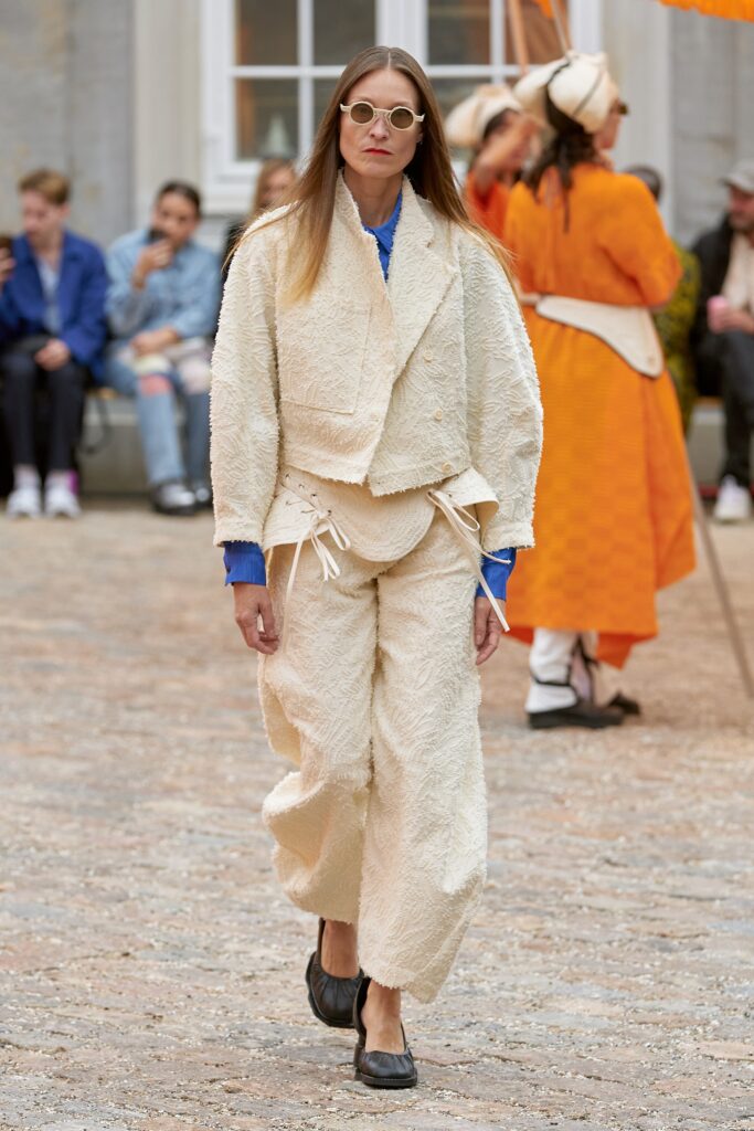 A relaxed beige cotton jacket with long sleeves, paired with matching pants featuring a textured design.