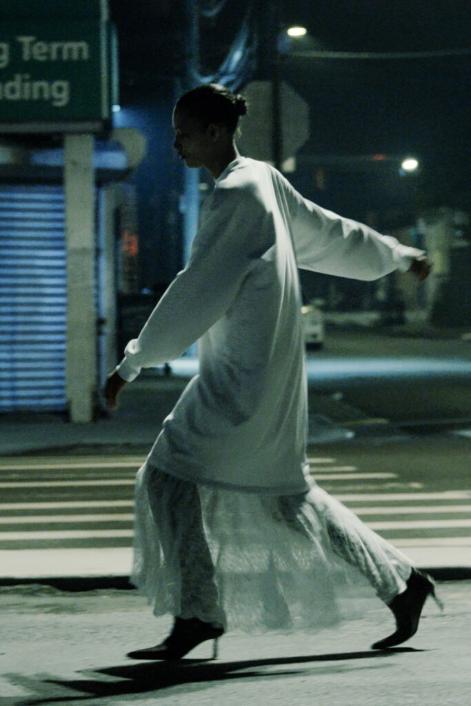 A relaxed white lace long-sleeve dress with a high neckline and layered design.