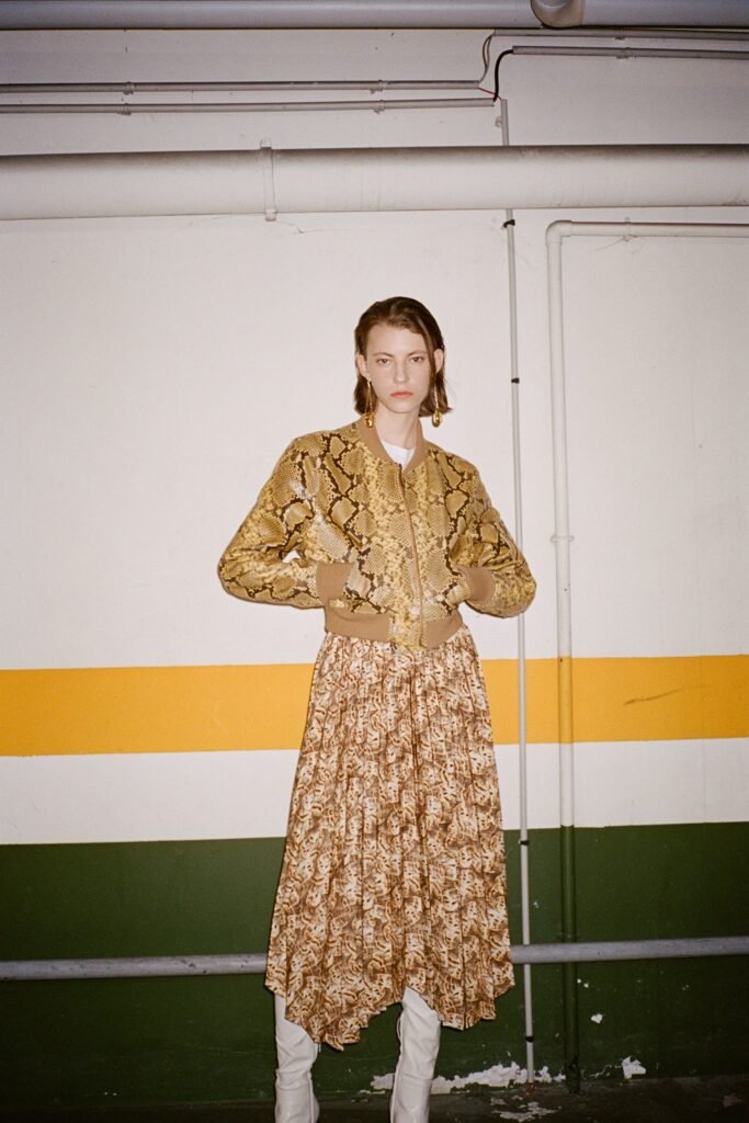A relaxed brown and gold printed jacket layered over a tiered dress.