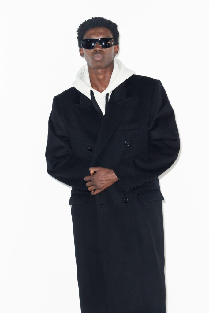 An oversized black wool coat with long sleeves and a double-breasted design.