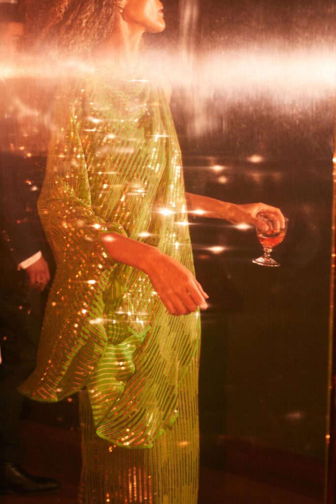 A relaxed green silk sleeveless dress with a high neckline and layered design.