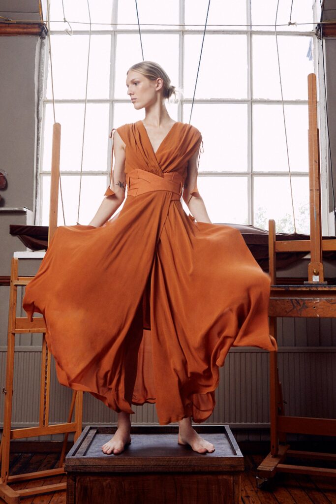 A relaxed orange silk sleeveless dress with a V-neckline and tiered design.